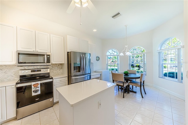 kitchen with white cabinets, appliances with stainless steel finishes, plenty of natural light, and pendant lighting