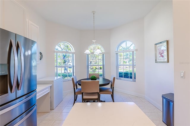 dining room with a chandelier and light tile patterned flooring