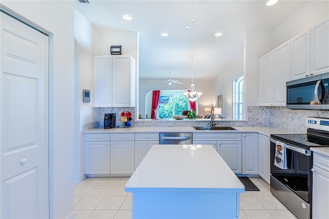 kitchen with a center island, backsplash, sink, white cabinetry, and stainless steel appliances