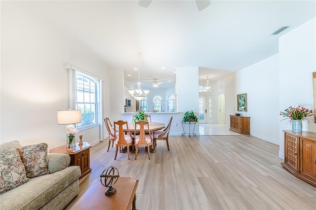 dining space with ceiling fan and light hardwood / wood-style flooring