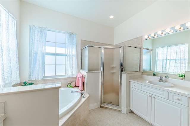 bathroom with plus walk in shower, vanity, and a wealth of natural light