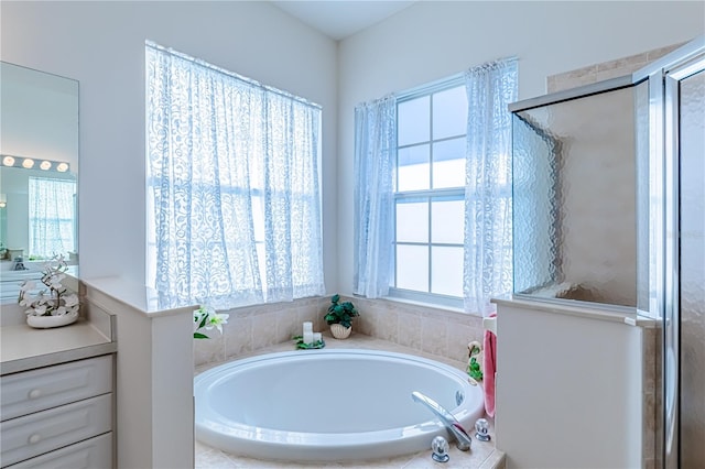 bathroom with a wealth of natural light, vanity, and independent shower and bath