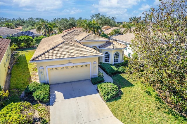 mediterranean / spanish home featuring a garage and a front yard