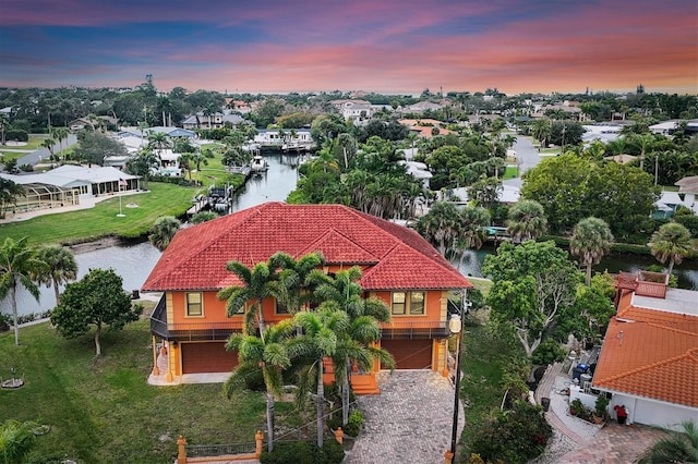 aerial view at dusk featuring a water view