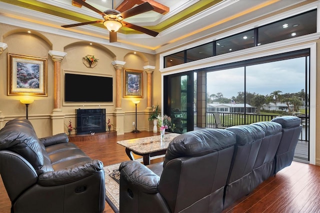 living room featuring a raised ceiling, crown molding, ceiling fan, and dark hardwood / wood-style floors