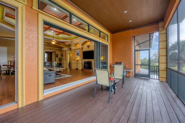 sunroom / solarium featuring a tray ceiling and ceiling fan