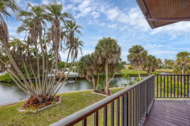 wooden deck featuring a water view and a lawn