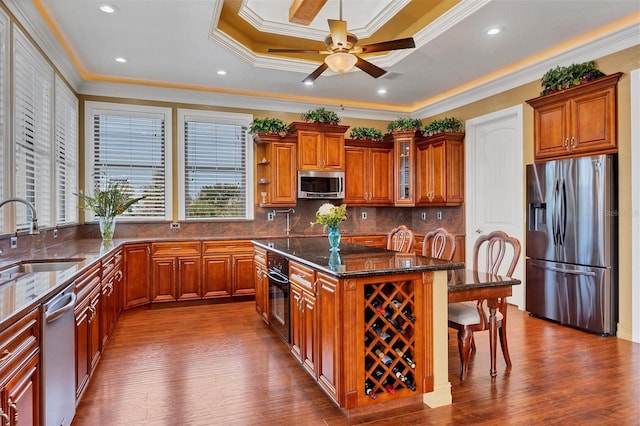 kitchen featuring sink, dark wood-type flooring, decorative backsplash, appliances with stainless steel finishes, and ornamental molding