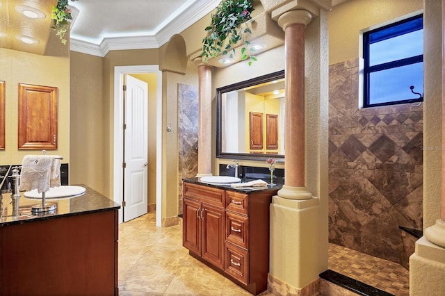 bathroom featuring vanity, crown molding, a textured ceiling, a tile shower, and decorative columns