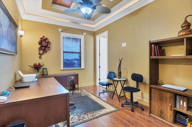 home office with hardwood / wood-style floors, a raised ceiling, ceiling fan, and crown molding