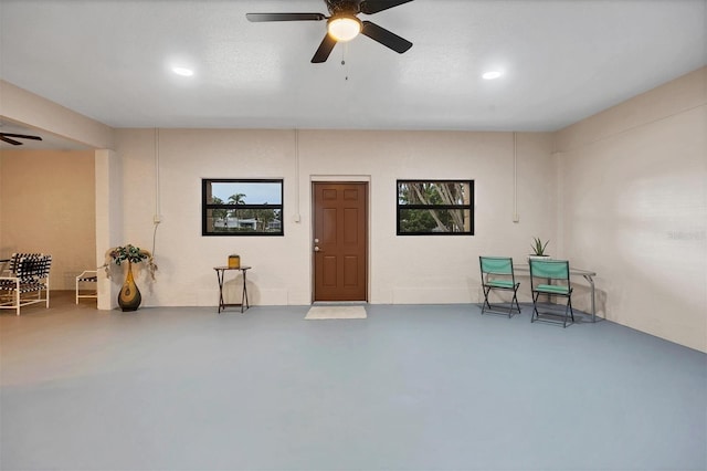 living area featuring concrete floors and ceiling fan