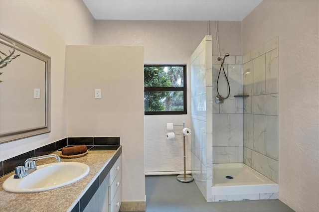 bathroom featuring a tile shower and vanity