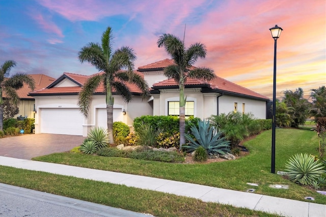 view of front of home featuring a garage and a lawn