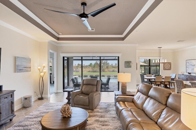 tiled living room with a textured ceiling, crown molding, a tray ceiling, and ceiling fan with notable chandelier