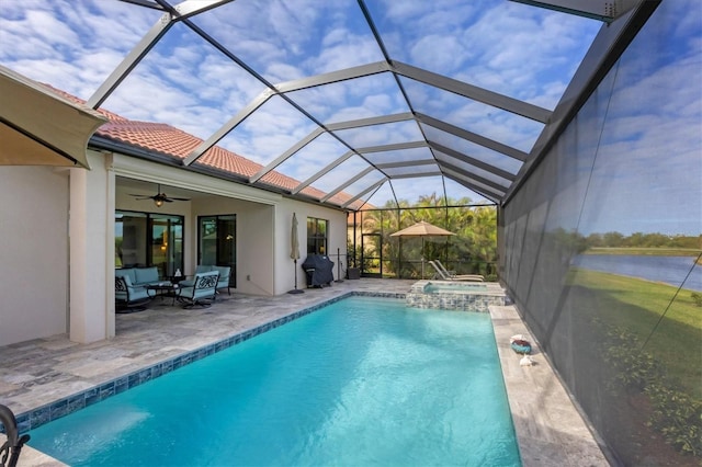 view of pool featuring glass enclosure, ceiling fan, an outdoor living space, an in ground hot tub, and a patio