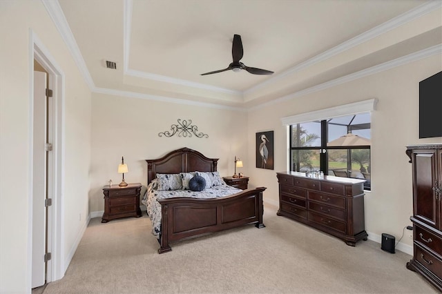 carpeted bedroom with ceiling fan, crown molding, and a tray ceiling