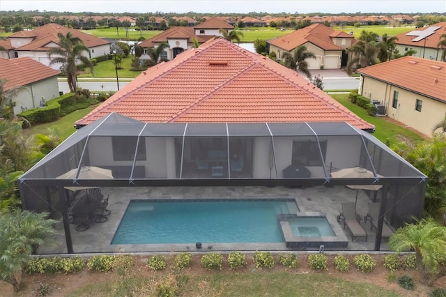 back of property with a pool with hot tub, a patio area, and central air condition unit