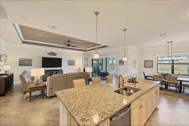 kitchen with light stone countertops, sink, ceiling fan, and a healthy amount of sunlight