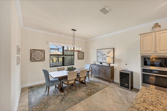 dining space with a chandelier, wine cooler, ornamental molding, and light tile patterned flooring