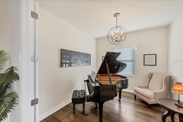 miscellaneous room with a notable chandelier and dark hardwood / wood-style floors