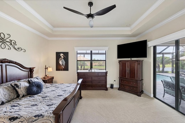 carpeted bedroom with ceiling fan, access to exterior, ornamental molding, and a tray ceiling