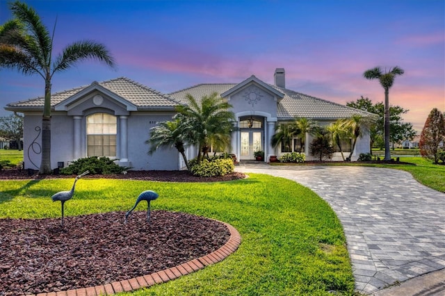 view of front of property featuring a lawn and french doors