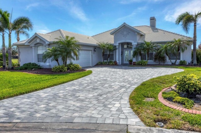 view of front of home with a front yard and a garage