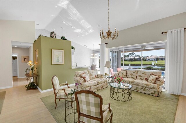 living room featuring light hardwood / wood-style floors, high vaulted ceiling, and a chandelier