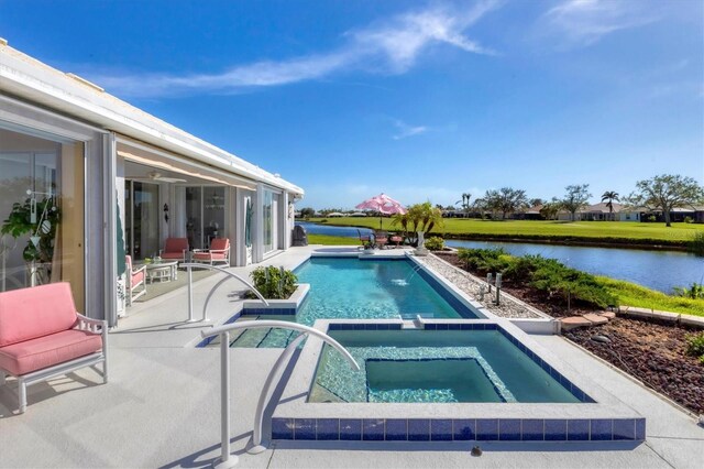 view of swimming pool featuring a patio area, a water view, and an in ground hot tub