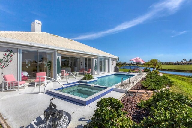 view of swimming pool featuring a patio area, an in ground hot tub, and a water view