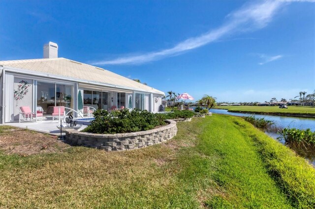 exterior space with a water view, a yard, and a patio