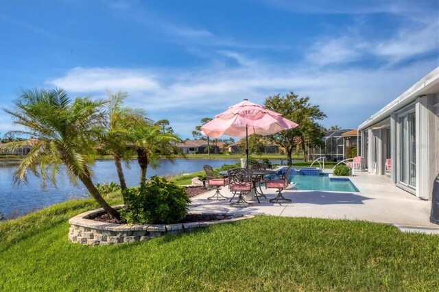 view of swimming pool with a patio, a water view, and a lawn