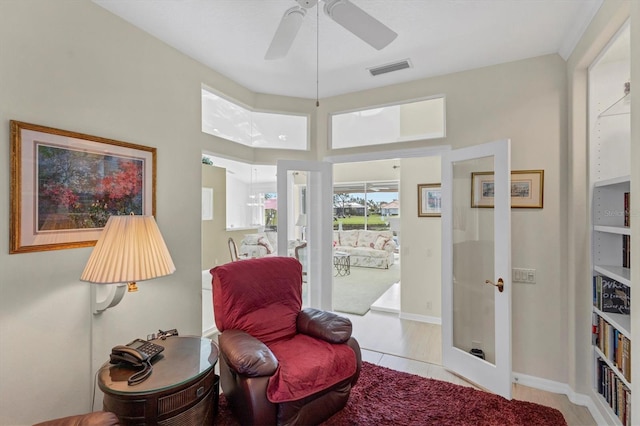 living area with french doors, light wood-type flooring, and ceiling fan