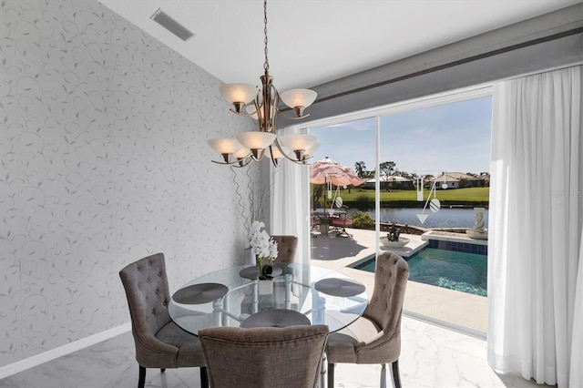 dining space with a water view and a chandelier