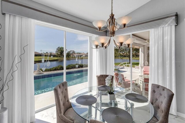 dining room with a water view, a wealth of natural light, and a chandelier