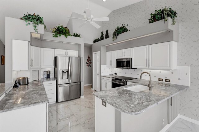 kitchen featuring high vaulted ceiling, white cabinets, sink, kitchen peninsula, and stainless steel appliances