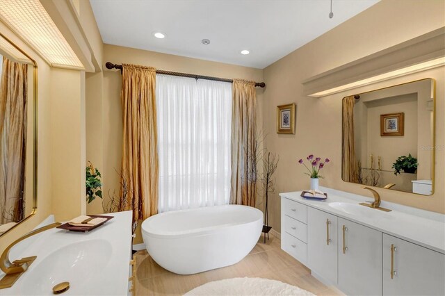 bathroom with tile patterned flooring, vanity, and a tub to relax in