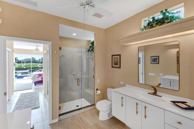 bathroom featuring vanity, toilet, walk in shower, and a wealth of natural light