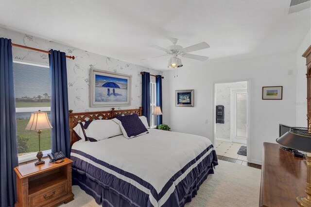 carpeted bedroom with connected bathroom and ceiling fan