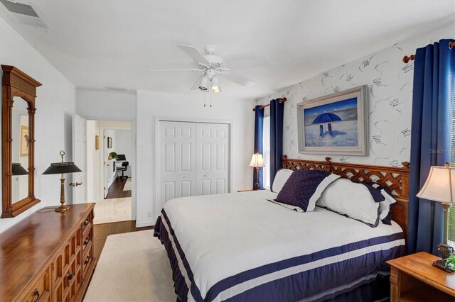 bedroom with multiple windows, ceiling fan, a closet, and hardwood / wood-style flooring