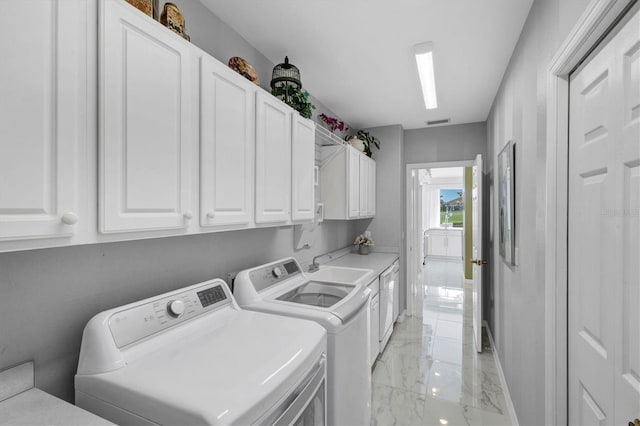 washroom with washer and clothes dryer, cabinets, and sink