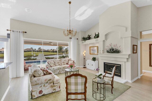 living room with light wood-type flooring, an inviting chandelier, and lofted ceiling