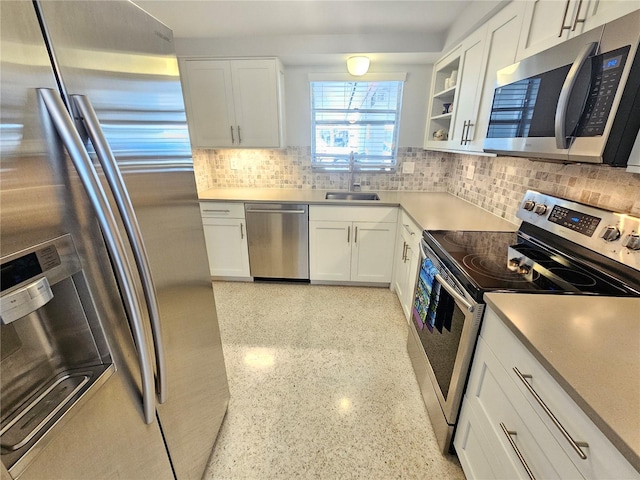 kitchen with backsplash, white cabinetry, and stainless steel appliances