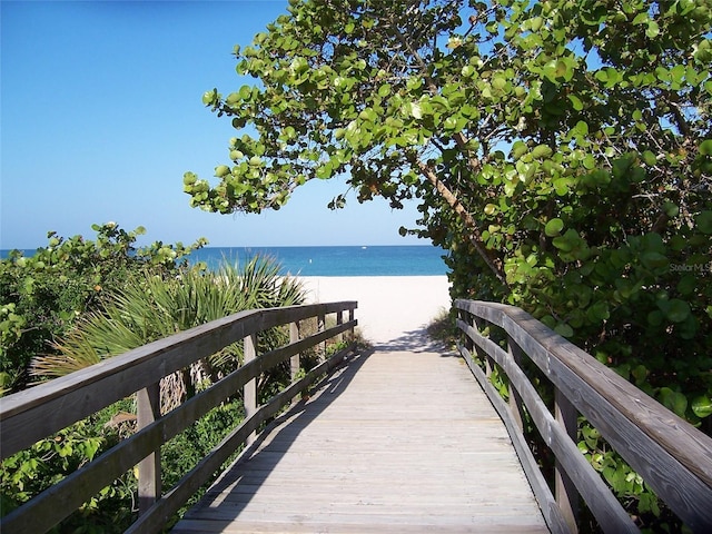 view of community featuring a water view and a beach view