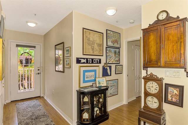 doorway to outside featuring a textured ceiling and hardwood / wood-style flooring