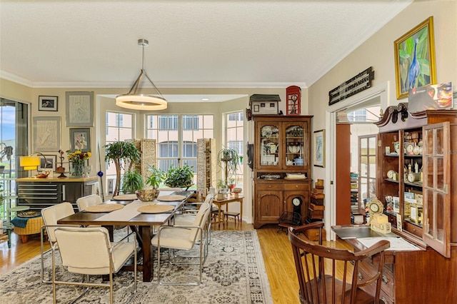 dining room featuring light wood-type flooring and ornamental molding