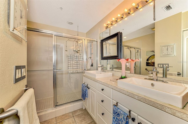 bathroom featuring tile patterned floors, vanity, an enclosed shower, and a textured ceiling