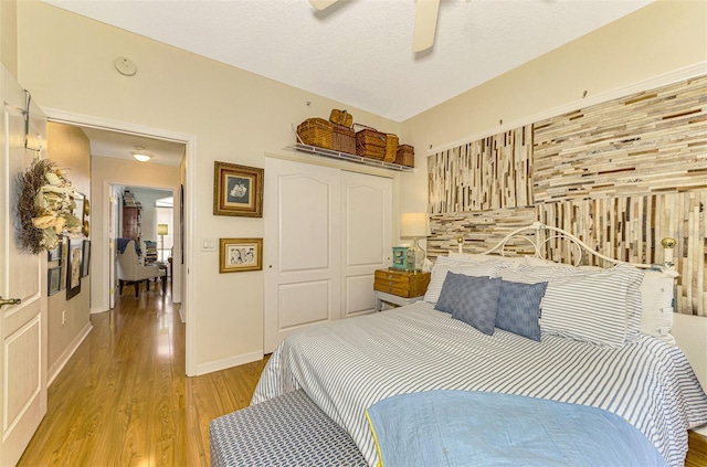 bedroom featuring a textured ceiling, light hardwood / wood-style floors, and ceiling fan