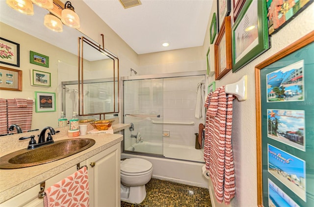 full bathroom featuring shower / bath combination with glass door, vanity, and toilet