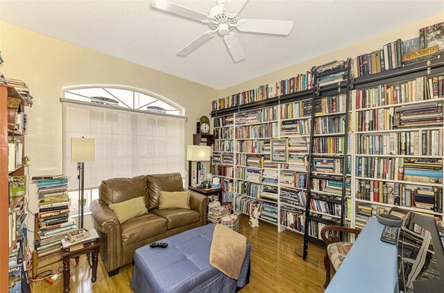 living area with hardwood / wood-style floors, a textured ceiling, and ceiling fan